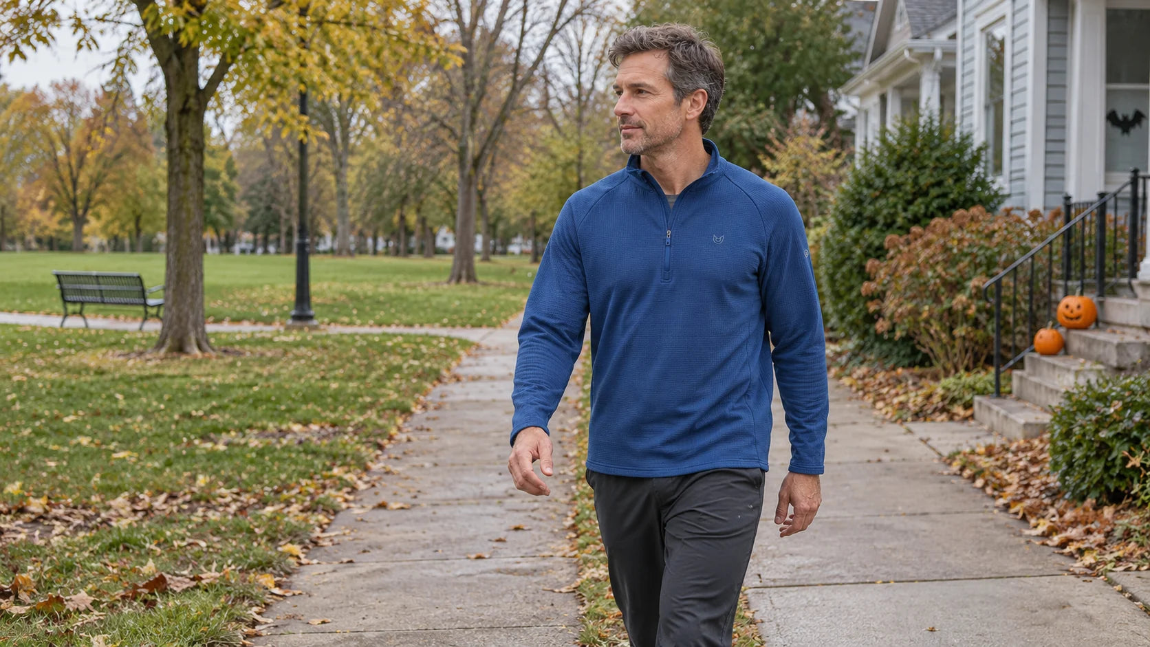 Generated campaign concept of a man in a blue quarter-zip walking beside a porch with small Halloween pumpkins